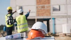 engineer and architect working with blueprints discuss at the outdoors construction site