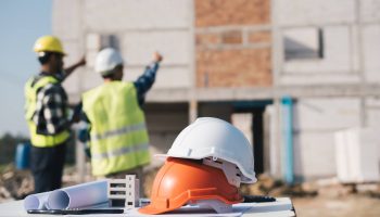 Engineer And Architect Working With Blueprints Discuss At The Outdoors Construction Site