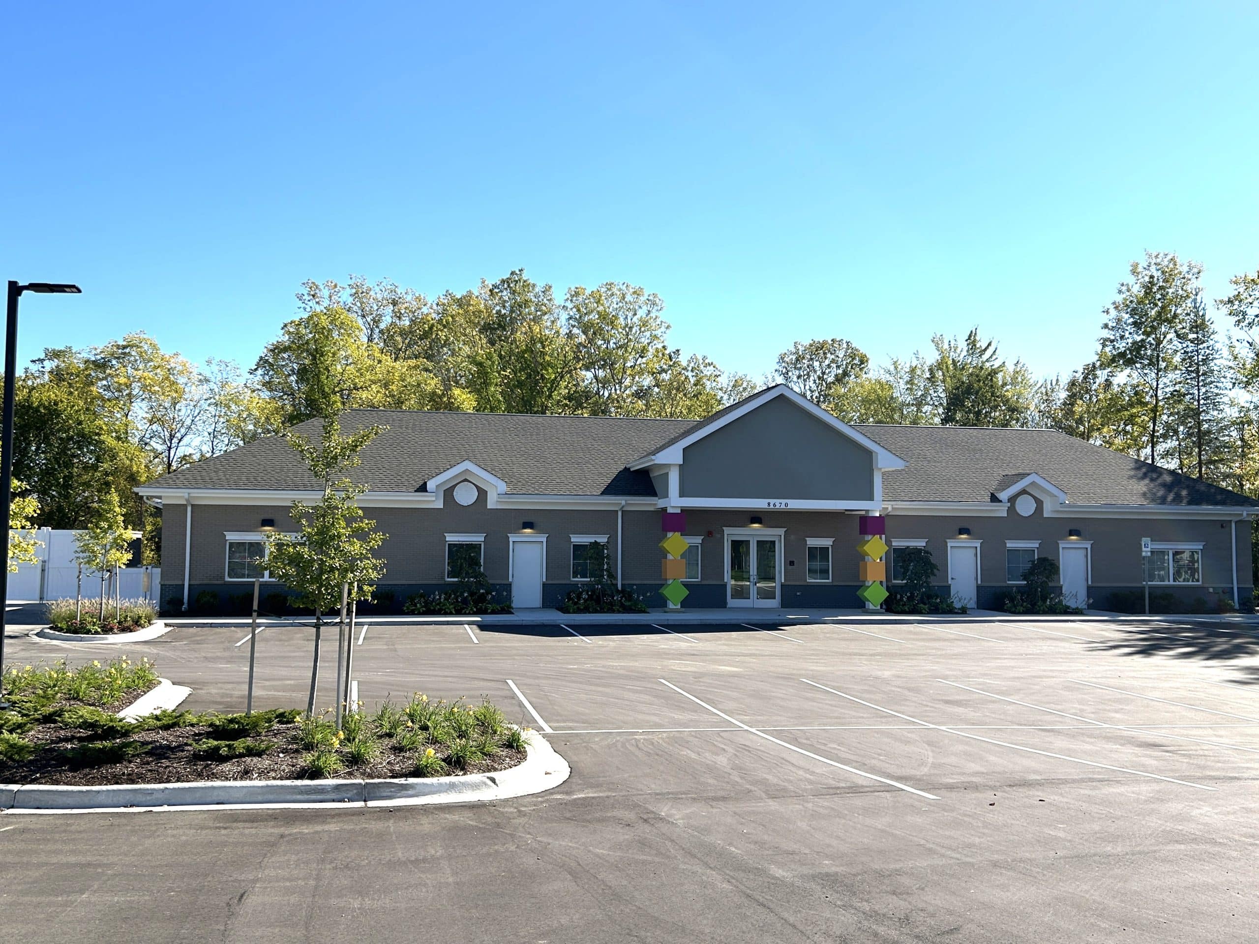 Completed childcare facility exterior showcasing modern construction, clean architectural design, and ample parking, reflecting a finished commercial development ready for operation.