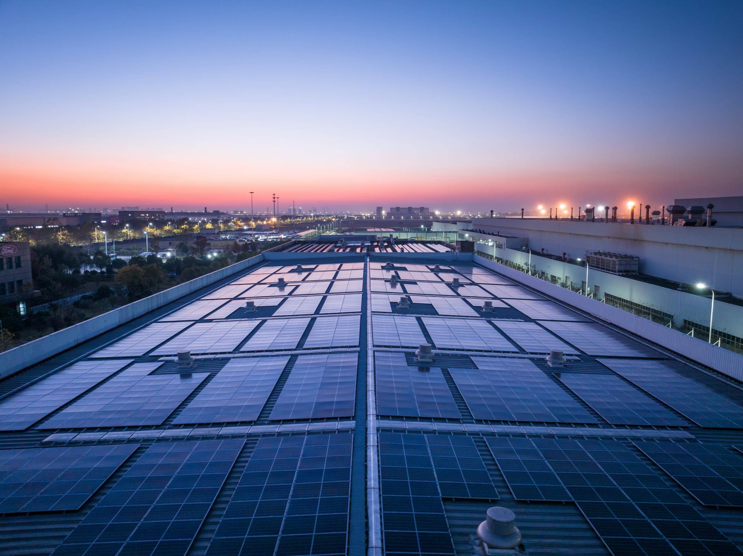 Photo looking along a commercial rooftop, covered in solar panels.
