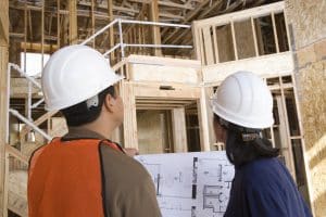 Commercial construction project manager reviewing progress with subcontractors on site.