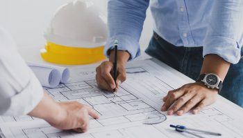 A Business Owner Works On Design Build Commercial Plans With His Contractor.