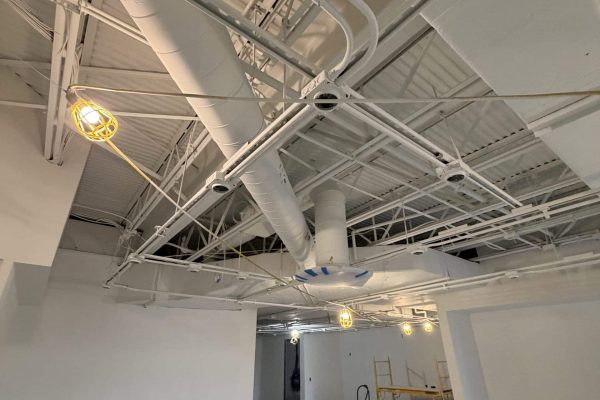 Commercial interior under construction with exposed HVAC ductwork and steel ceiling, a Schonsheck build-out in Michigan