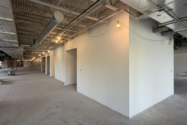 Commercial interior build-out in progress with framed walls and exposed ceiling