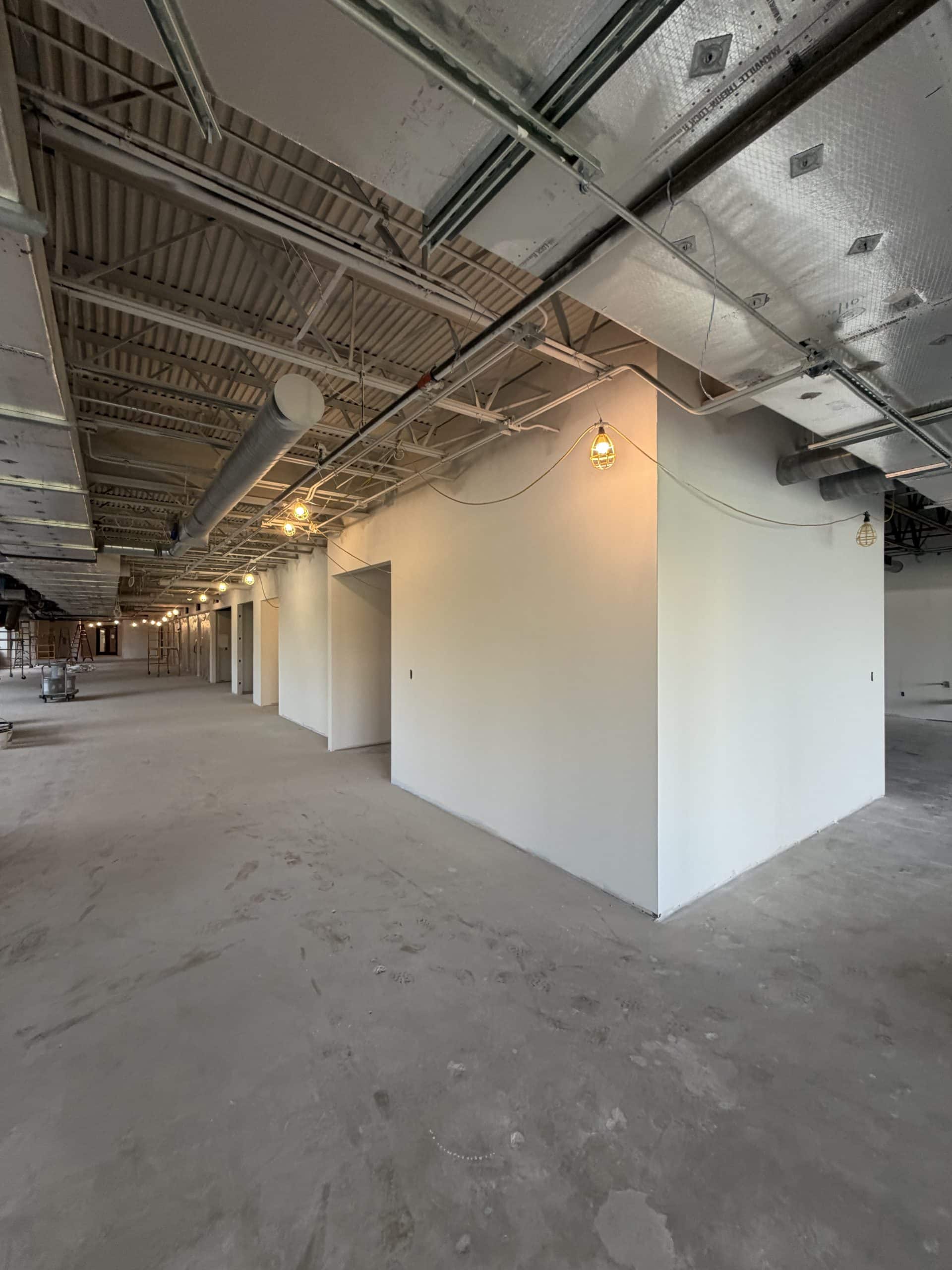Commercial interior build-out in progress with framed walls and exposed ceiling