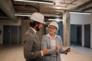 Two site leaders walking through a commercial jobsite to review progress, safety, and work quality.