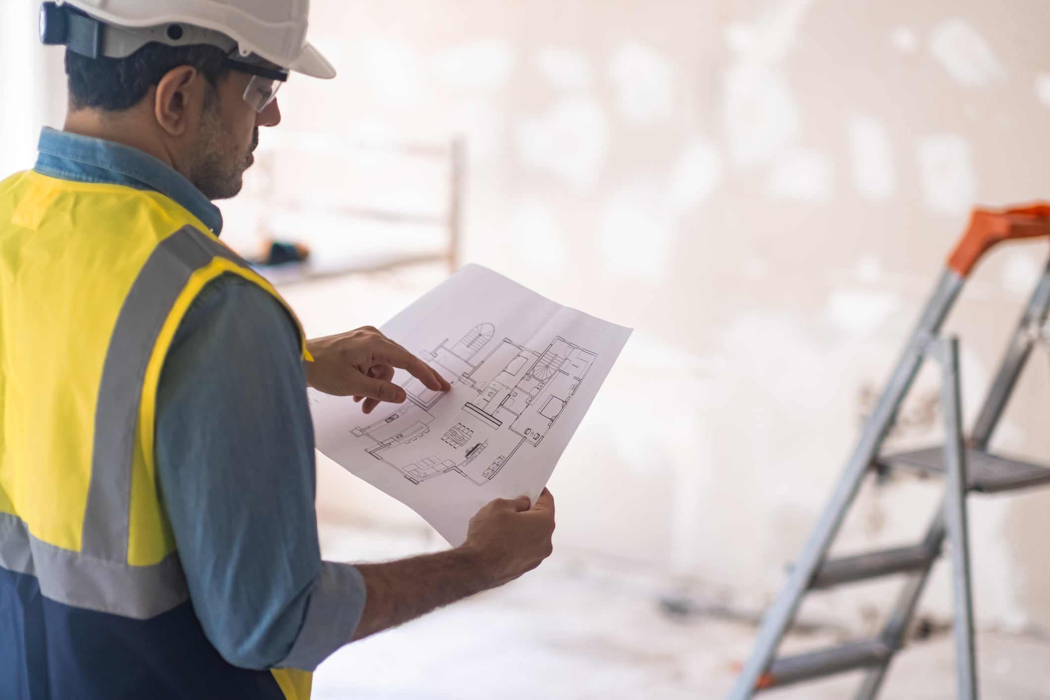 Commercial contractor reviewing building plans at an active construction site.